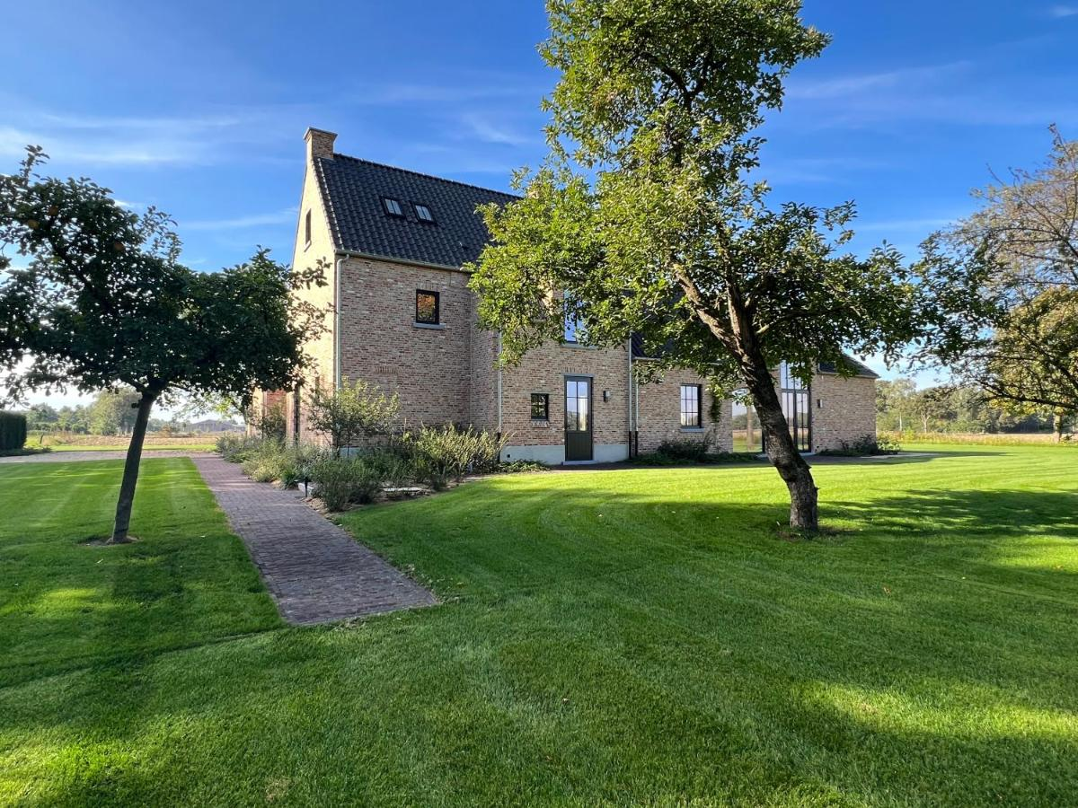 Achteraanzicht van Pastorijwoning omringd met een grote groene tuin